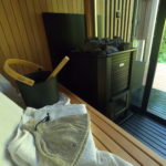 Interiér kontajnerovej sauny so saunovacím vedrom a sauna pecou